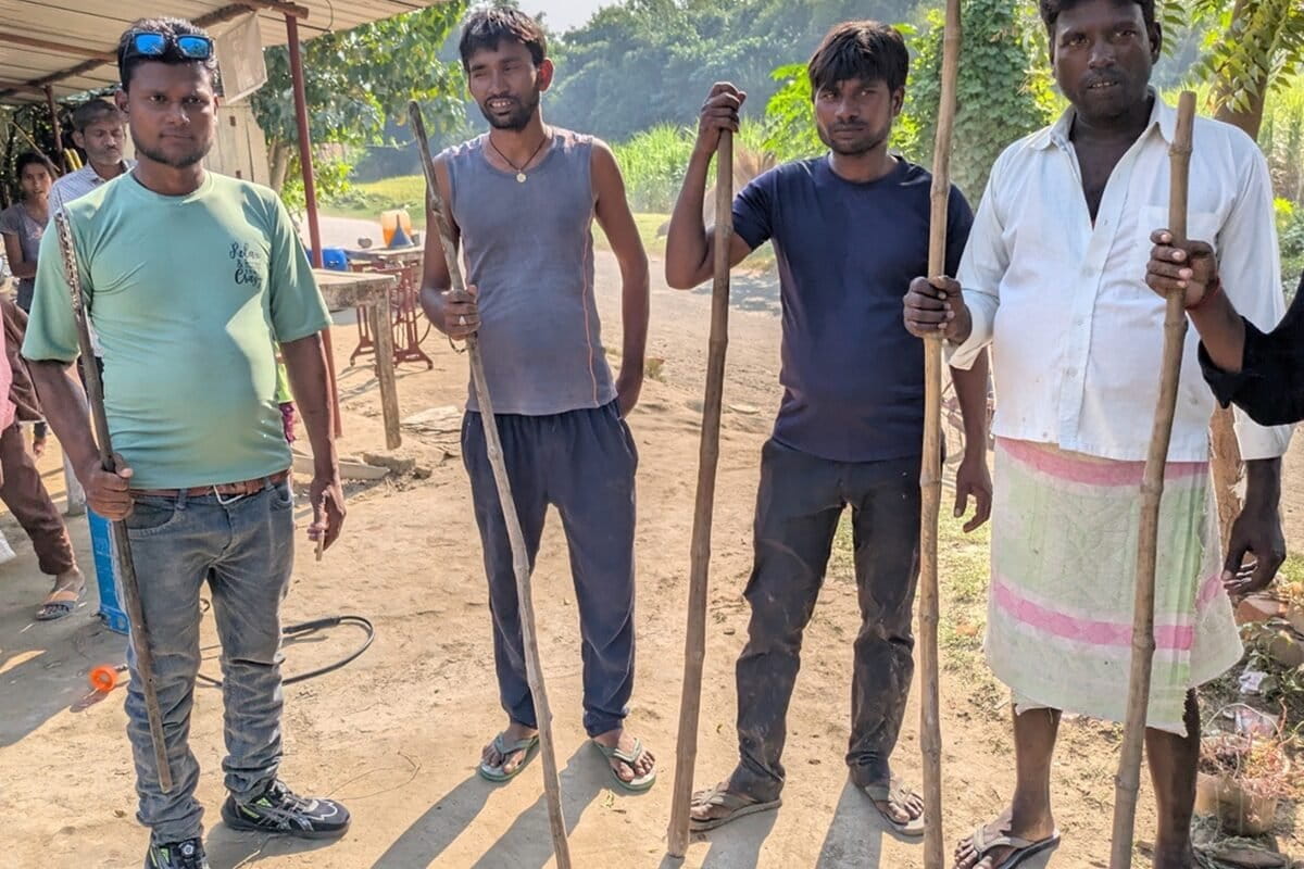 Indal Chauhan, wearing a green t-shirt, stands with villagers guarding their village from wild animals during the day. Image by Saurabh Sharma.
