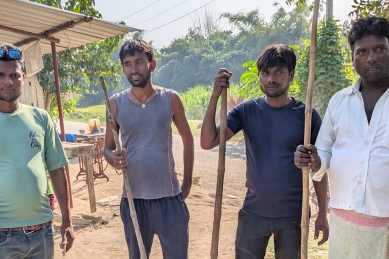 Indal Chauhan, wearing a green t-shirt, stands with villagers guarding their village from wild animals during the day. Image by Saurabh Sharma.