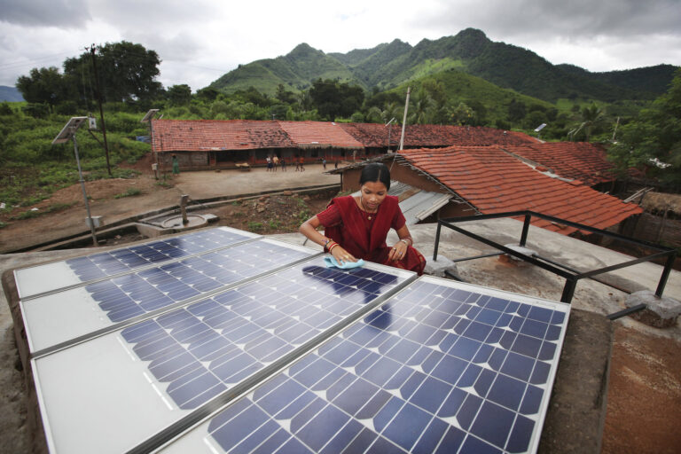 A solar engineer cleans a rooftop panel in Maharashtra. India needs nearly $467 billion in climate investments by 2030, in steel, cement, power, and transport sectors, according to a recent assessment. Representative image © Abbie Trayler-Smith / Panos Pictures / Department for International Development via Flickr (CC BY-NC-ND 2.0).