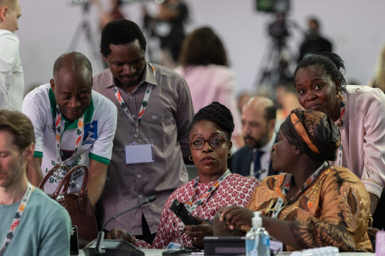 Delegates speak before the start of the closing plenary at COP30. The assessment says that industry lobbyists and business groups shape climate obstruction in the Global South, often undermining the demands and concerns of Indigenous peoples, thus also weakening their ability to influence the proceedings. Image © UN Climate Change - Kiara Worth via Flickr (CC BY-NC-SA 4.0).