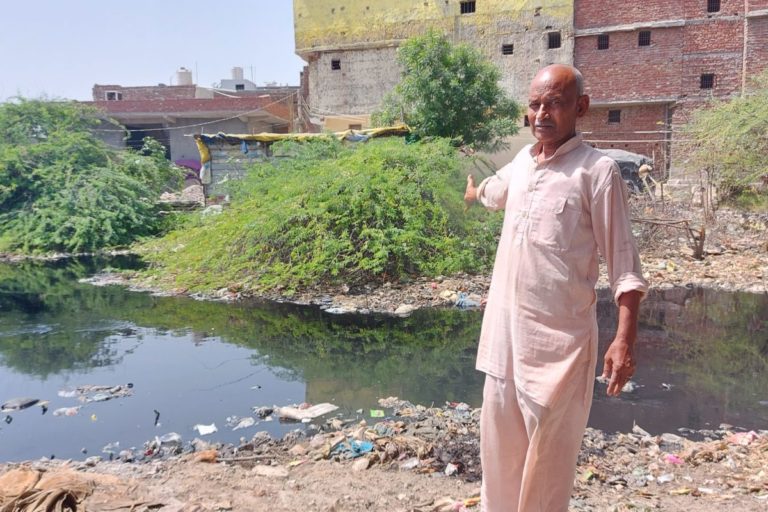 कुंडली गांव के निवासी सुभाष चंद एक नाला दिखाते हुए, जिसमें स्थानीय उद्योगों के रासायनिक प्रदूषित पानी को छोड़ा जाता है। तस्वीर- सत सिंह/मोंगाबे।