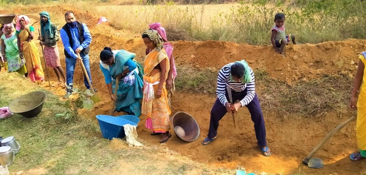 पहाड़ी नाली बनाने में अन्य मजदूरों का सहयोग करतीं चामी मुर्मू। पहाड़ पर जब बारिश होती है तो पानी तेजी से नीचे आता है, जिसे इस नाली की मदद से इकट्ठा किया जाता है। तस्वीर साभार- सहयोगी महिला