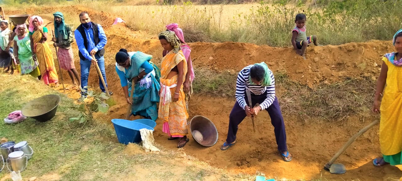 पहाड़ी नाली बनाने में अन्य मजदूरों का सहयोग करतीं चामी मुर्मू। पहाड़ पर जब बारिश होती है तो पानी तेजी से नीचे आता है, जिसे इस नाली की मदद से इकट्ठा किया जाता है। तस्वीर साभार- सहयोगी महिला