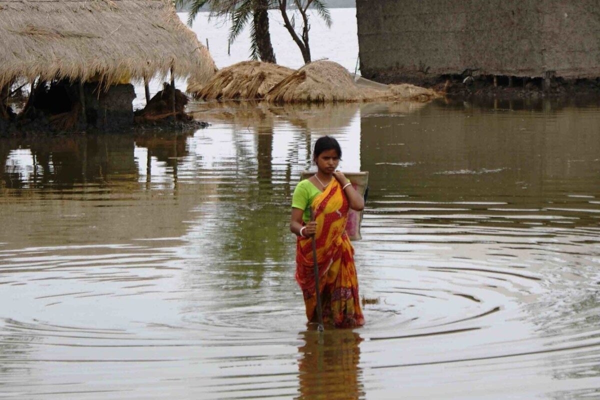 चक्रवात आलिया के बाद बाढ़ के पानी में चलती हुई महिला। तस्वीर अनिल गुलाटी/इंडिया वाटर पोर्टल/ फ्लिकर  (CC BY-NC-SA 2.0)।